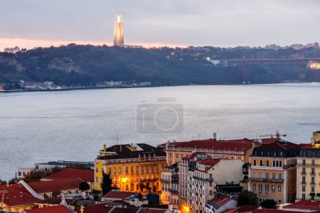 Foto de La vista del río Tajo en la noche con el Santuario de Cristo Rey en el fondo. Lisboa, Portugal. - Imagen libre de derechos
