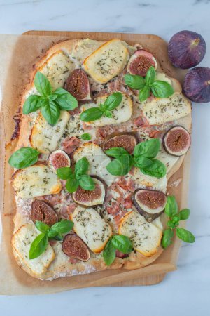 Photo for A vertical shot of a fig pizza with cheese and thyme on a white background - Royalty Free Image