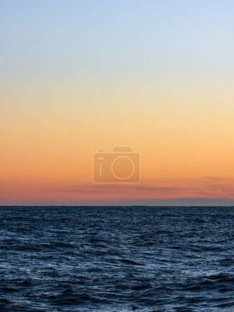 Téléchargez les photos : Vue paisible du coucher de soleil violet sur l'océan bleu - en image libre de droit