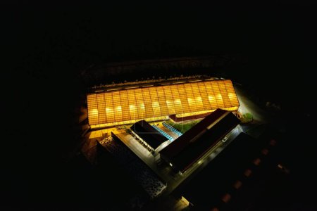 Photo for An aerial view of an illuminated cowshed at night - Royalty Free Image