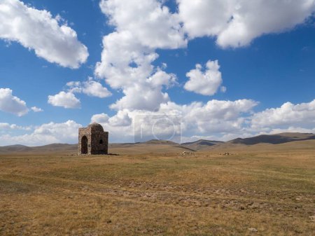 Foto de Un antiguo edificio Tian Shan montañas con un cielo azul nublado en el fondo, Kirguistán - Imagen libre de derechos