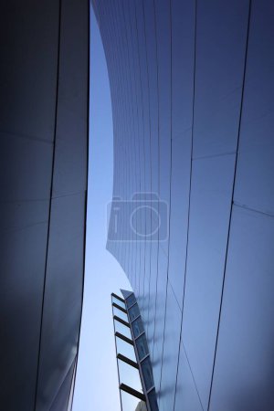 Foto de Un plano vertical de ángulo bajo de un edificio moderno bajo el cielo azul, fresco para el fondo - Imagen libre de derechos