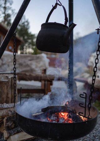 Téléchargez les photos : Un gros plan d'une théière suspendue sur le feu de joie - en image libre de droit