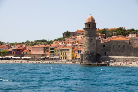 Téléchargez les photos : Une mer avec un port couvert de bâtiments, phare et touristes, Collioure, France - en image libre de droit