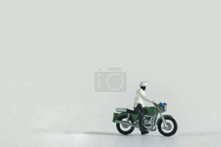 Photo for A close-up shot of a miniature figurine of a man on a motorcycle isolated on a white background - Royalty Free Image