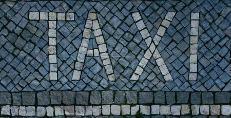 Téléchargez les photos : Une vue de dessus sur un texte "TAXI" lettré par des pavés et des rochers - en image libre de droit