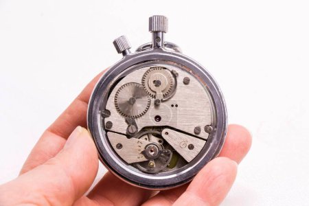 Foto de Un primer plano de una persona sosteniendo un viejo reloj de temporizador antiguo sobre un fondo blanco - Imagen libre de derechos