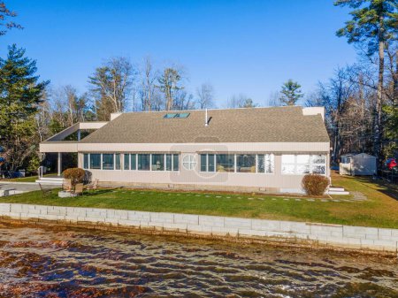 Téléchargez les photos : La nouvelle maison moderne au bord du lac avec par une journée ensoleillée - en image libre de droit