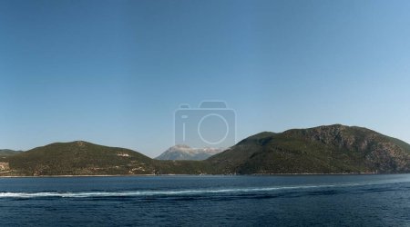 Photo for A seascape view at sunrise with misty mountains and clear sky background - Royalty Free Image