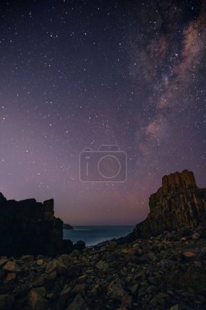 Photo for A vertical of the night sky full of stars in the Bombo Headland, Kiama, New South Wales, Australia - Royalty Free Image