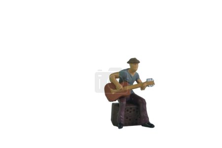Téléchargez les photos : Guitariste assis jouant de la musique, fond blanc, personnes miniatures - en image libre de droit