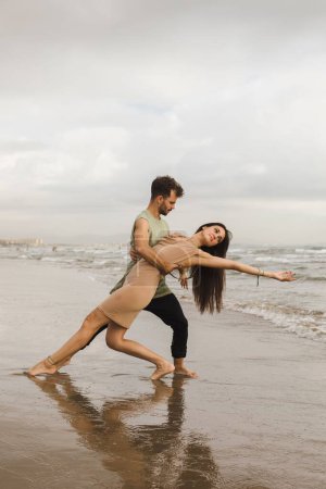 Photo for A Caucasian couple doing dance pose in beach - Royalty Free Image