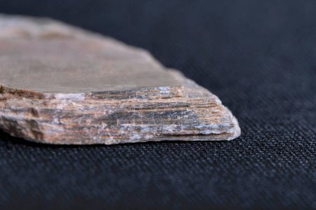 Foto de Un primer plano de una pieza de roca esquistica sobre el oscuro fondo borroso - Imagen libre de derechos