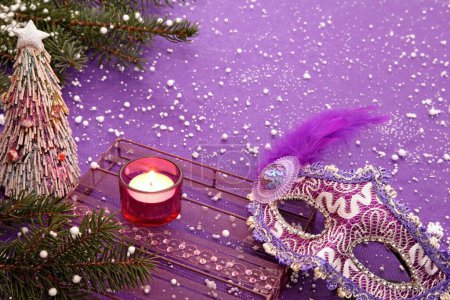 Téléchargez les photos : Nouvel An, Noël, composition de Noël d'une bougie, un masque de carnaval, une figurine d'arbre de Noël à la main et des branches de sapin. - en image libre de droit