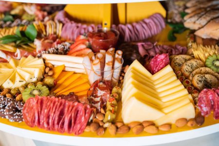 Téléchargez les photos : Un gros plan de délicieux fruits frais, fromage et pain sur le stand à la table de mariage - en image libre de droit