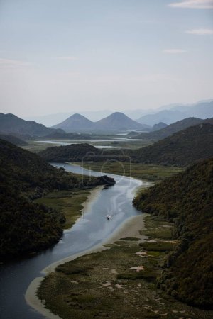Foto de Una vista aérea del río Rijeka Crnojevica rodeado de exuberante vegetación verde de Montenegro - Imagen libre de derechos