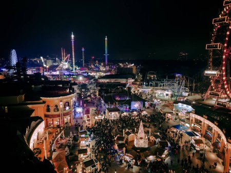 Photo for A drone view of a brightly illuminated Christmas winter market in the Prater Amusement park full of visitors - Royalty Free Image