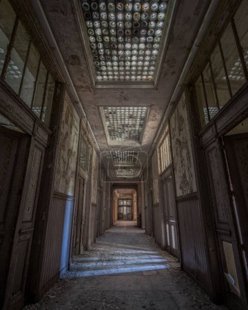 Photo for A vertical shot of the corridor of an old abandoned building with the decayed doors - Royalty Free Image