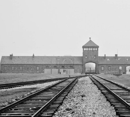 Foto de Un disparo a escala de grises de la vieja vía férrea vacía en el campo de concentración de Auschwitz - Imagen libre de derechos
