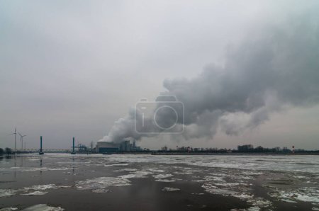 Foto de Vapor procedente de centrales eléctricas de carbón y turbinas eólicas de los alrededores para simbolizar el cambio climático. - Imagen libre de derechos