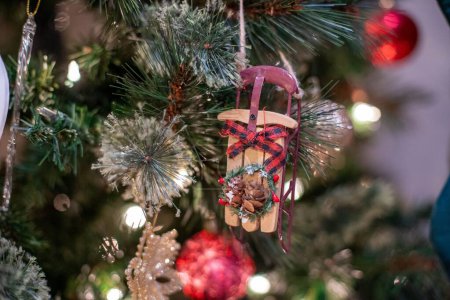 Téléchargez les photos : Une petite décoration de Noël suspendue au sapin de Noël sur le fond flou - en image libre de droit