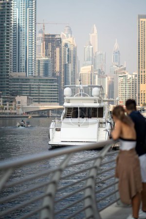 Téléchargez les photos : Un plan vertical d'un couple regardant un yacht à Dubai Marina. - en image libre de droit