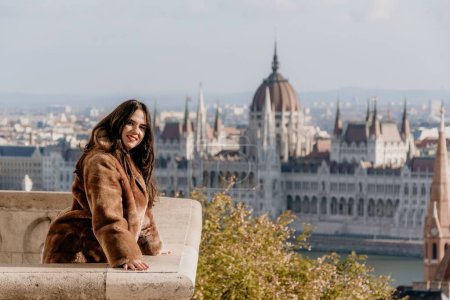 Photo for A portrait of a young female on a balcony overlooking Hungarian Parliament, Budapest - Royalty Free Image