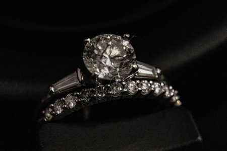 Téléchargez les photos : Un gros plan de bague de fiançailles en diamant et bande de mariage en diamant sur fond noir - en image libre de droit