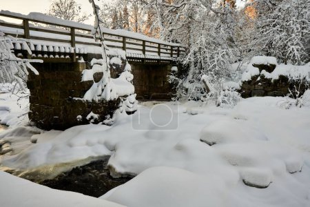 Photo for A beautiful shot of a footbridge across a frozen river during winter - Royalty Free Image