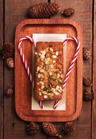 Photo for A top view of a custard cake on a wooden plate with Christmas decorations - Royalty Free Image