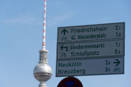 Photo for A closeup shot of a street sign showing directions to Alexanderplatz, Schlobplaz, and Kreuxberg on a blue sky background - Royalty Free Image