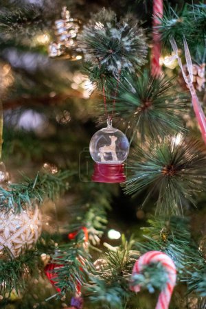Foto de Un plano vertical de una pequeña decoración navideña colgada del árbol de Navidad - Imagen libre de derechos