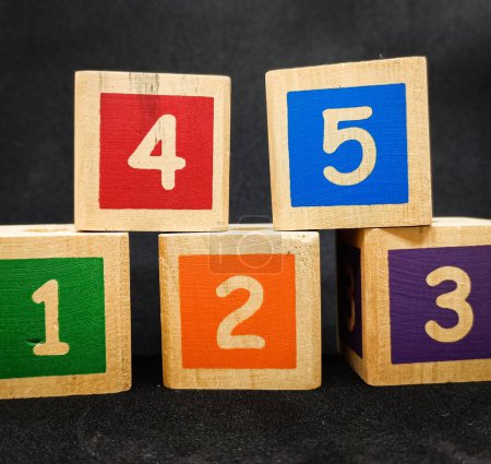 Foto de Bloques coloridos con números uno, dos, tres, cuatro y cinco, este es un juguete para que los niños aprendan a reconocer colores y números, fondo negro - Imagen libre de derechos