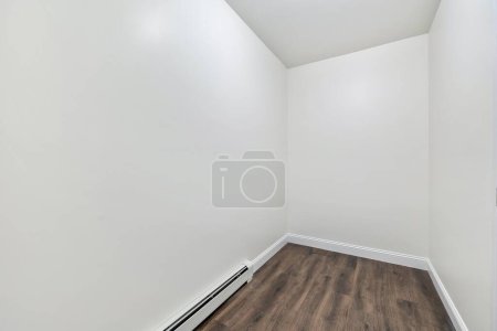 Photo for The interior of a room with a parquet floor, white walls and a baseboard heater - Royalty Free Image