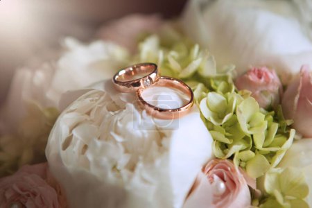 Foto de Un primer plano de anillos de boda dorados en el ramo nupcial sobre un fondo aislado - Imagen libre de derechos