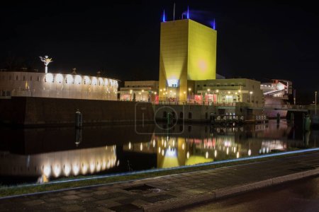 Téléchargez les photos : Le Musée de Groningue réfléchissant sur un lac la nuit aux Pays-Bas - en image libre de droit