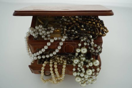 Téléchargez les photos : Un gros plan de colliers extra longs en fausse perle dans un bijou vintage en bois - en image libre de droit