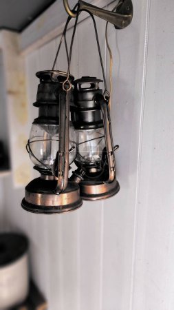 Foto de Una toma vertical de una lámpara de queroseno vintage cuelga de la pared - Imagen libre de derechos