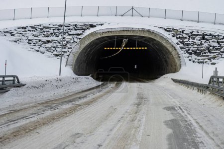 Téléchargez les photos : Une route menant à un tunnel dans la neige - en image libre de droit