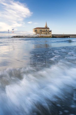 Téléchargez les photos : Un plan vertical de longue exposition des vagues de la mer avec l'église Sanctuaire de Madonna dell'Angelo - en image libre de droit