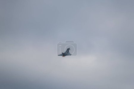 Téléchargez les photos : Vue aérienne d'un avion volant dans les airs en arrière-plan de nuages gris - en image libre de droit