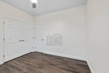 Photo for The interior of a parquet floor of a room with white walls and three doors - Royalty Free Image