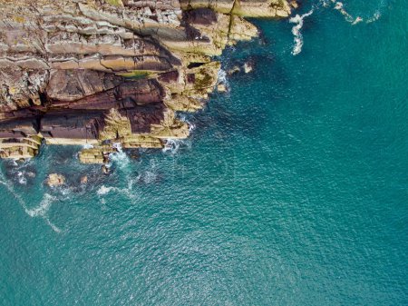 Téléchargez les photos : Une vue aérienne des falaises verdoyantes face à la mer le matin - en image libre de droit