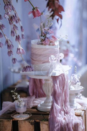Foto de Un pastel de boda decorativo floral con un arco rosa festivo en una mesa - Imagen libre de derechos