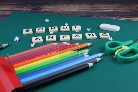 Photo for A closeup shot of a green surface with colorful wood pencils and a german school start sign - Royalty Free Image