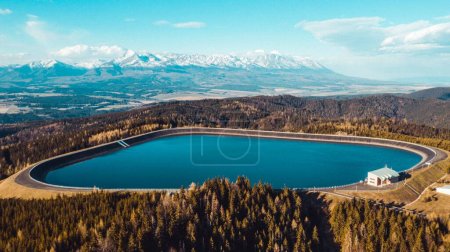 An aerial shot of Pumped Storage Power Plant Cierny Vah, High Tatras mountains in the background