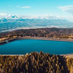 An aerial shot of Pumped Storage Power Plant Cierny Vah, High Tatras mountains in the background