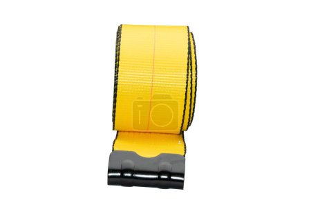 Foto de Un rollo de una correa de carga amarilla con hebilla de acero inoxidable para el portaequipajes sobre un fondo blanco - Imagen libre de derechos