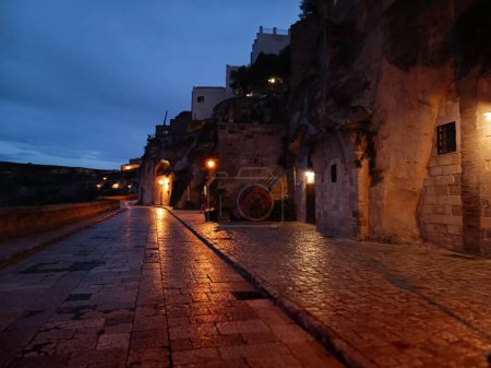 Téléchargez les photos : La rue de la ville Matera avec de vieux bâtiments éclairés par des lampes la nuit, Italie - en image libre de droit