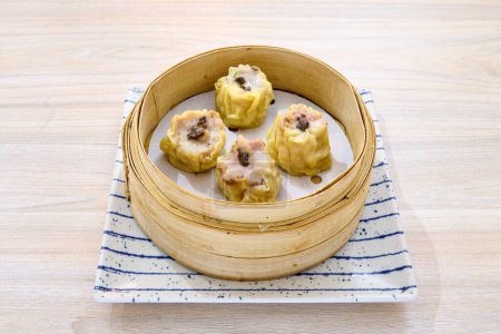 Foto de Un primer plano de deliciosas albóndigas de shumai chinas en una cesta humeante de bambú xiaolong - Imagen libre de derechos